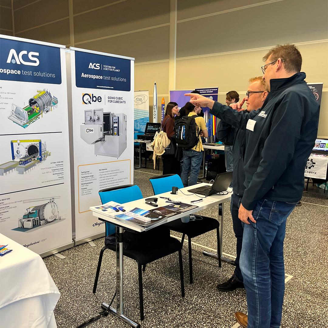 Visitors at the ACS booth during the SSEA Symposium in Monaco exploring space testing technologies